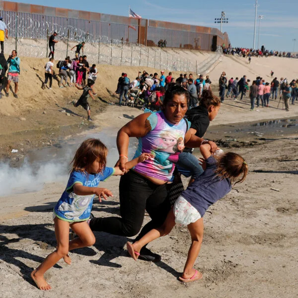 Familia de migrantes cruzando frontera USA